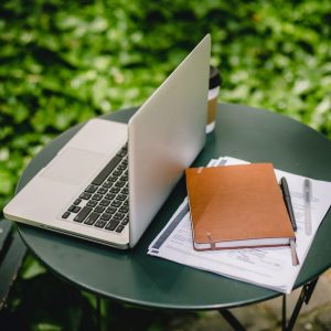 laptop and documents on a green table